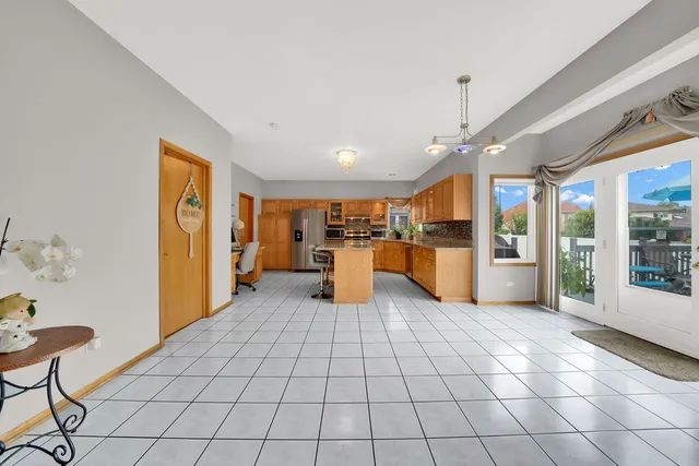 a large white kitchen with a stove a sink dishwasher and a refrigerator with wooden floor