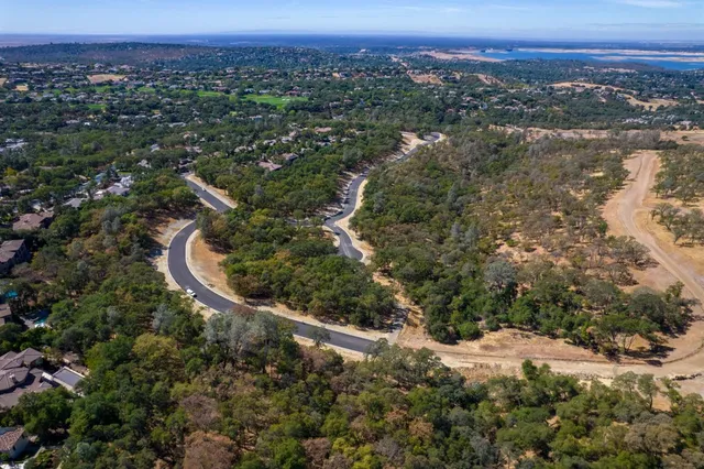 an aerial view of a house with a yard and lake view