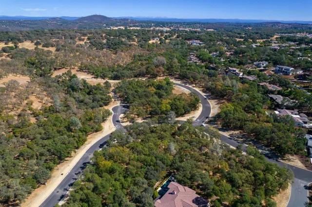 an aerial view of a house with a yard and lake view
