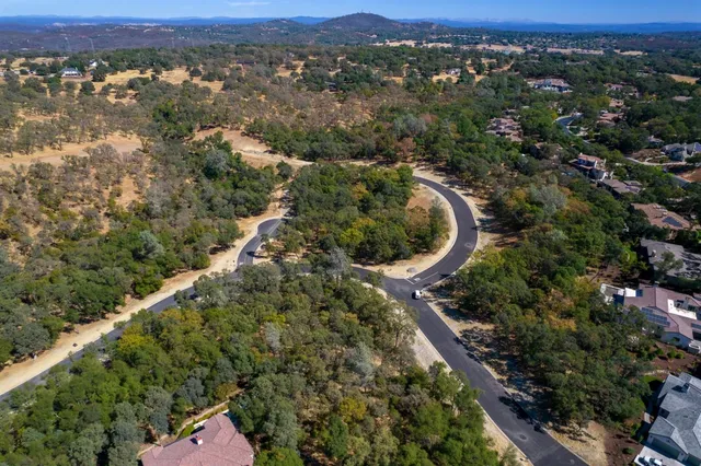 an aerial view of a house with a yard and mountain view in back