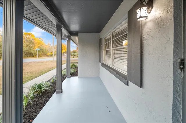 a view of a porch with furniture and floor to ceiling window