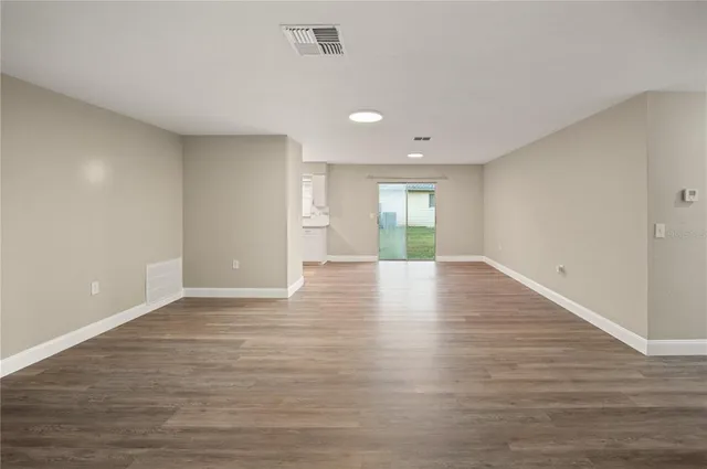 a view of empty room with wooden floor