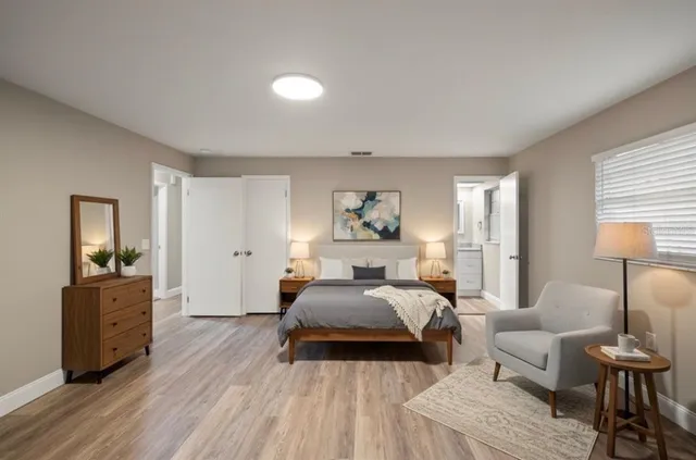 a spacious bedroom with a bed and wooden floor