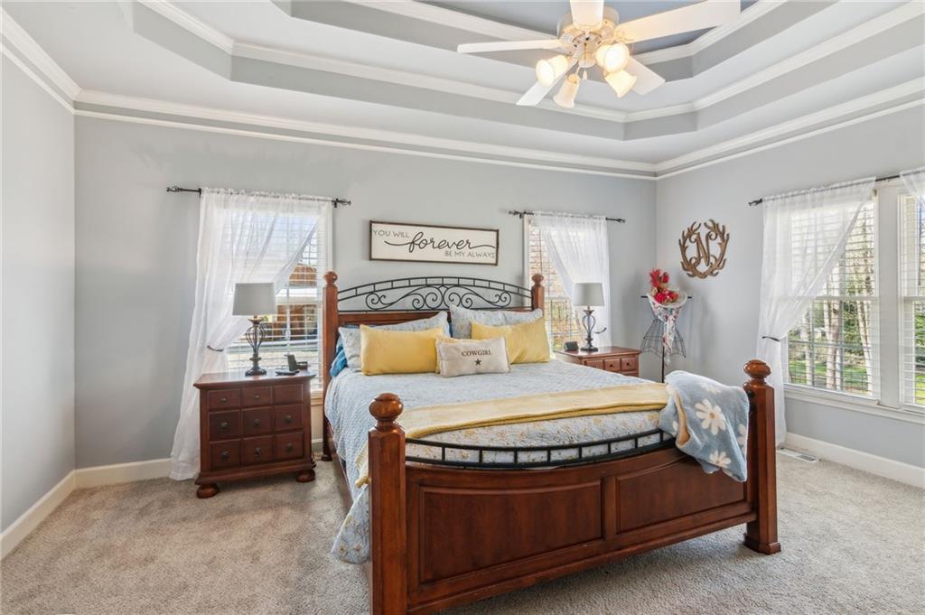 5388 Frazer Road Buford, GA 30518 - Photo 22 of 83 a bed sitting in a bedroom next to a window with a chandelier and dresser