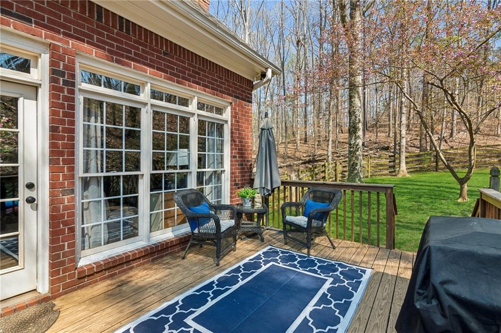 5388 Frazer Road Buford, GA 30518 - Photo 33 of 83 a view of a deck with couches table and chairs with wooden floor and fence