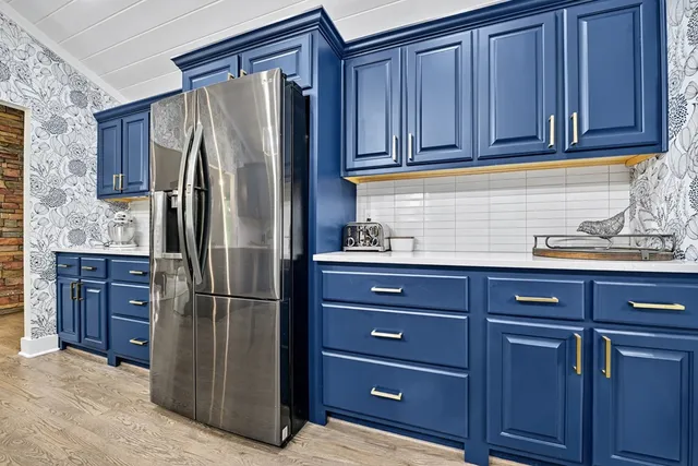 a kitchen with stainless steel appliances granite countertop a refrigerator a stove and a sink with cabinets