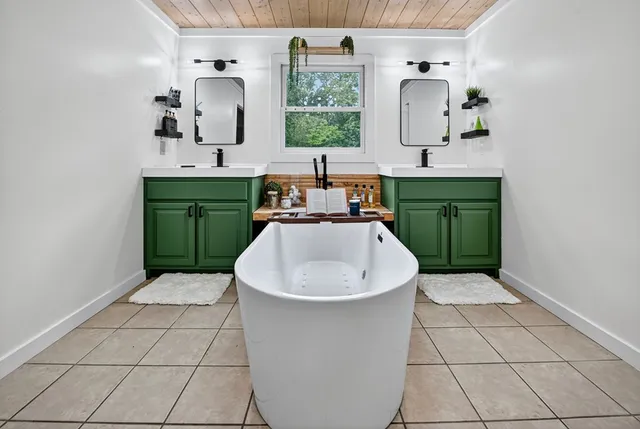 a bathroom with a double vanity sink a toilet a mirror and shower