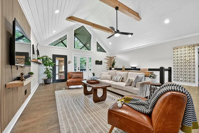 a living room with furniture a flat screen tv and kitchen view