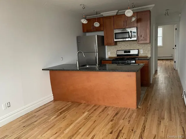 a kitchen with stainless steel appliances a refrigerator and a stove top oven