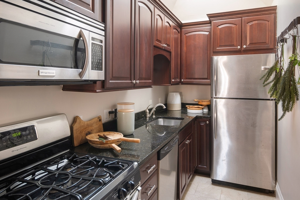 413 Beacon Street, Unit 5 Boston, MA 02115 - Photo 7 of 19 a kitchen with stainless steel appliances granite countertop a refrigerator stove and sink