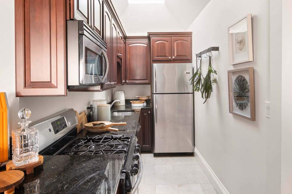 413 Beacon Street, Unit 5 Boston, MA 02115 - Photo 8 of 19 a kitchen with stainless steel appliances granite countertop a refrigerator sink and stove