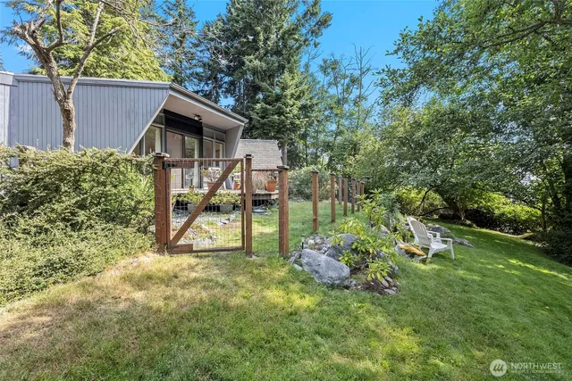 a view of a house with a backyard and trees