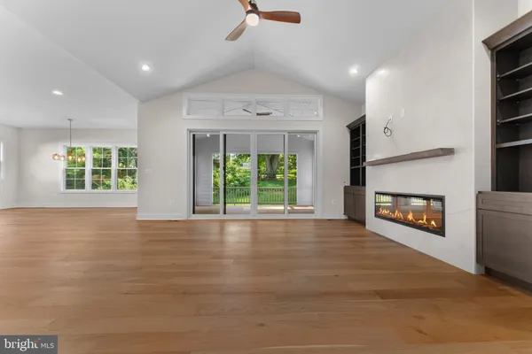 an empty room with windows and fireplace