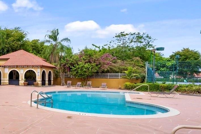 15550 Southwest 80th Street, Unit E101 Miami, FL 33193 - Photo 17 of 21 a view of a house with pool and a yard