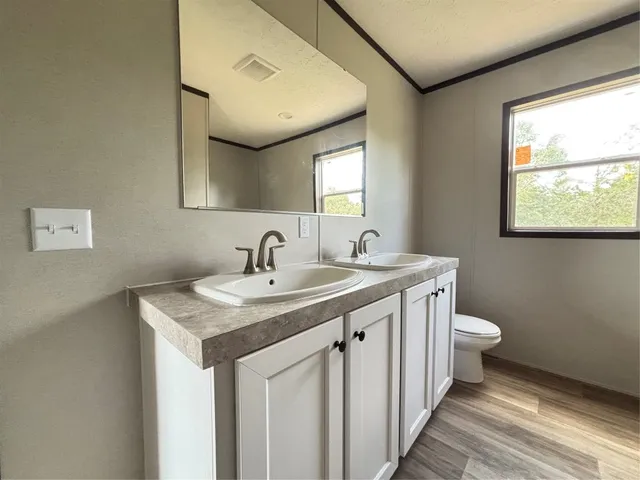 a view of a big room with wooden floor and windows