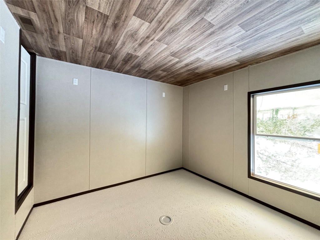 277 Elm Forest Loop, Unit B Cedar Creek, TX 78612 - Photo 18 of 26 a view of an empty room with wooden floor and a window