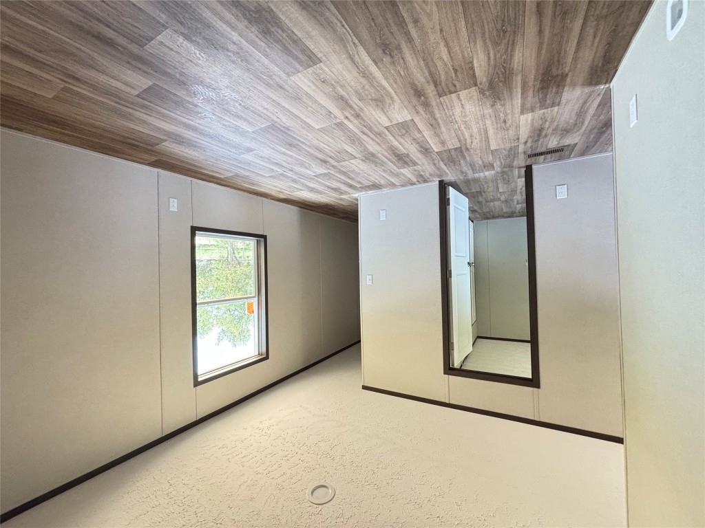 277 Elm Forest Loop, Unit B Cedar Creek, TX 78612 - Photo 20 of 26 an empty room with wooden floor closet and windows