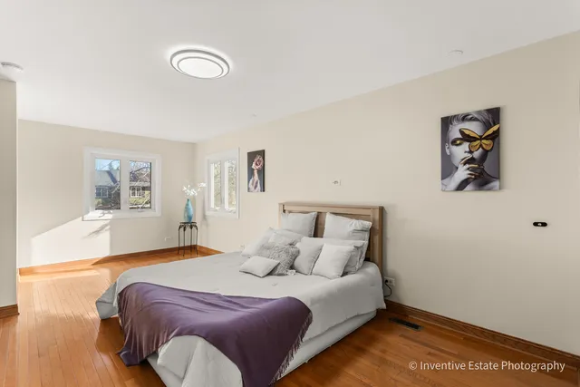 a bedroom with a bed and painting on the wall