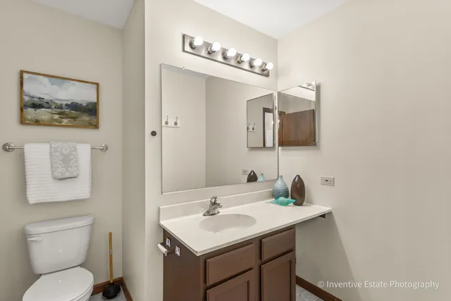 a bathroom with a toilet a sink and mirror