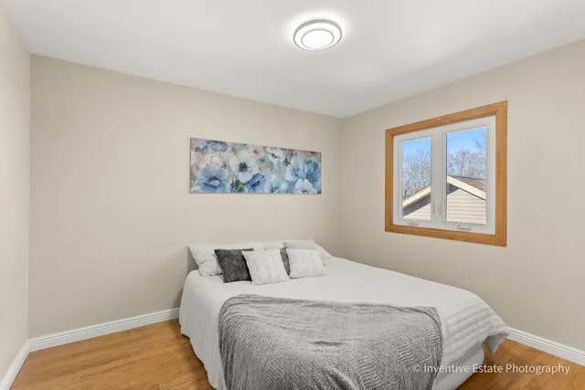 a bedroom with a bed and a painting on the wall