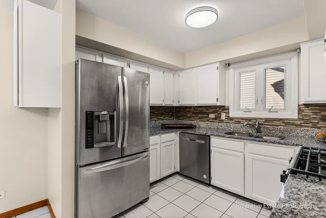a kitchen with granite countertop stainless steel appliances and white cabinets
