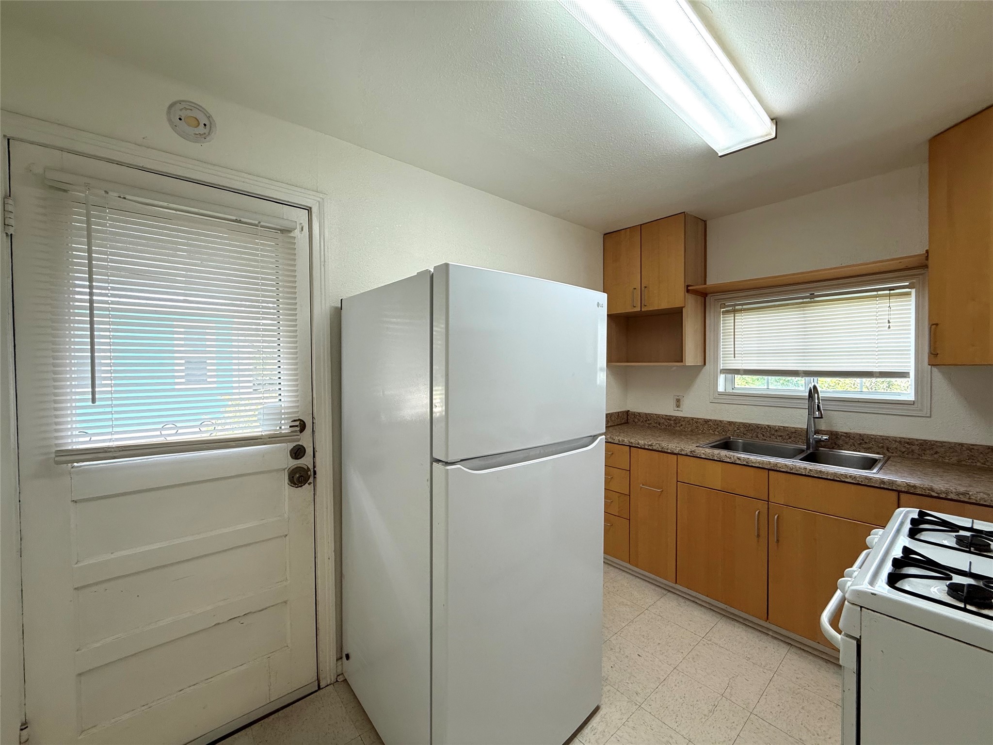 3305 Merrie Lynn Avenue Austin, TX 78722 - Photo 6 of 22 Functional kitchen with ample cabinet space, a dual basin sink, and a view of the outside.