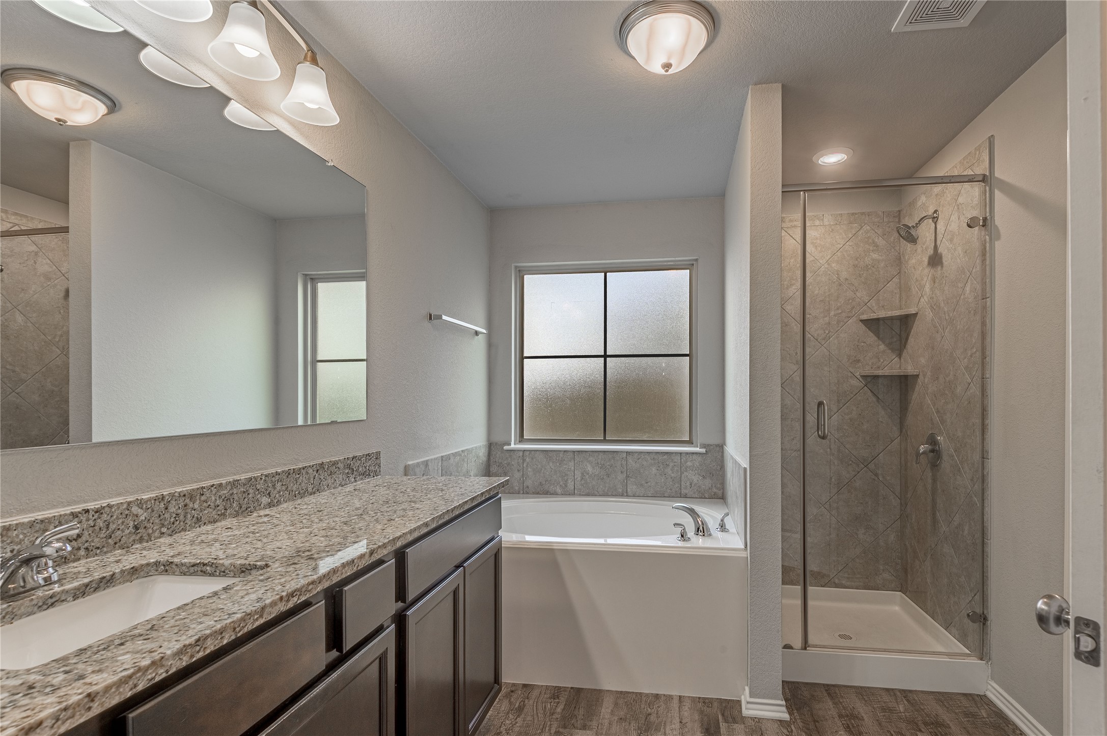 133 Bates Court Huntsville, TX 77320 - Photo 13 of 31 a bathroom with a granite countertop bathtub shower sink and mirror