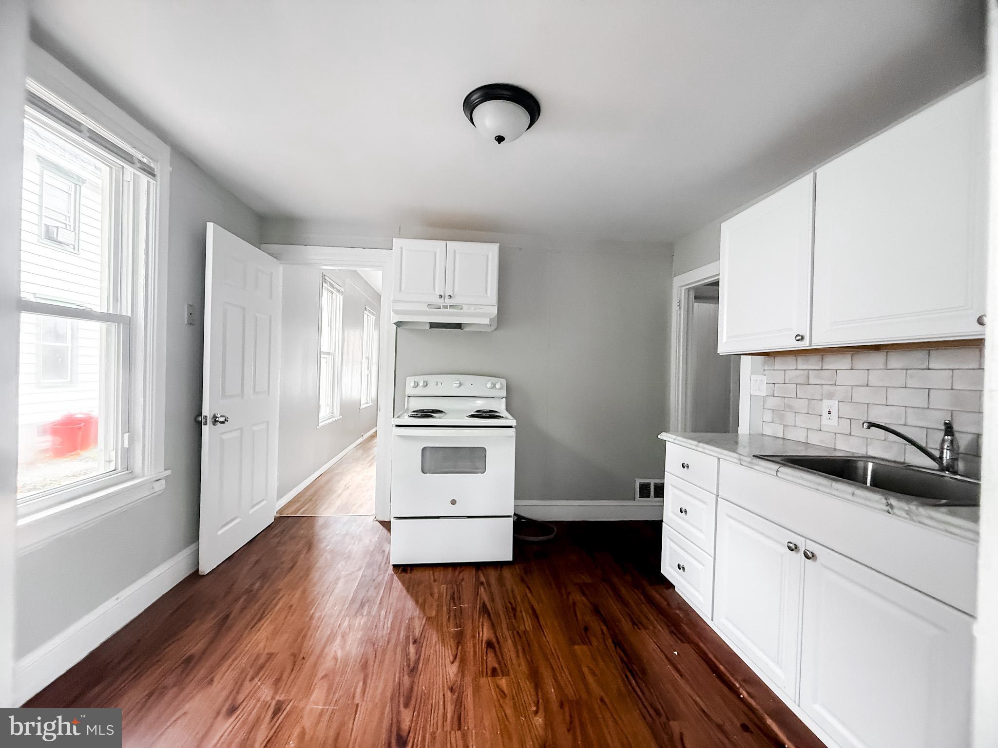 24 State Street, Unit A Penns Grove, NJ 08069 - Photo 11 of 18 a kitchen with white cabinets and appliances