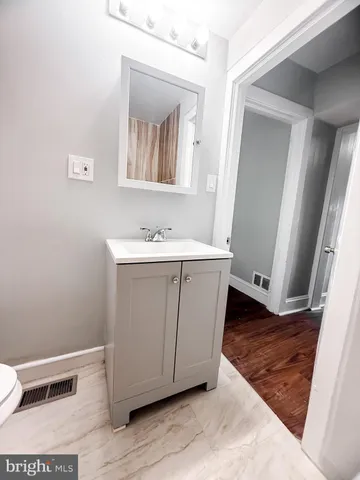 a bathroom with a sink a toilet and mirror