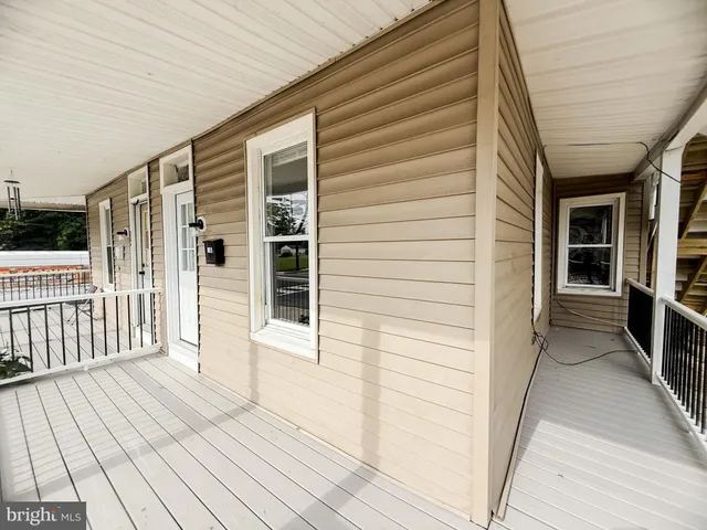 a view of a porch with wooden floor and fence