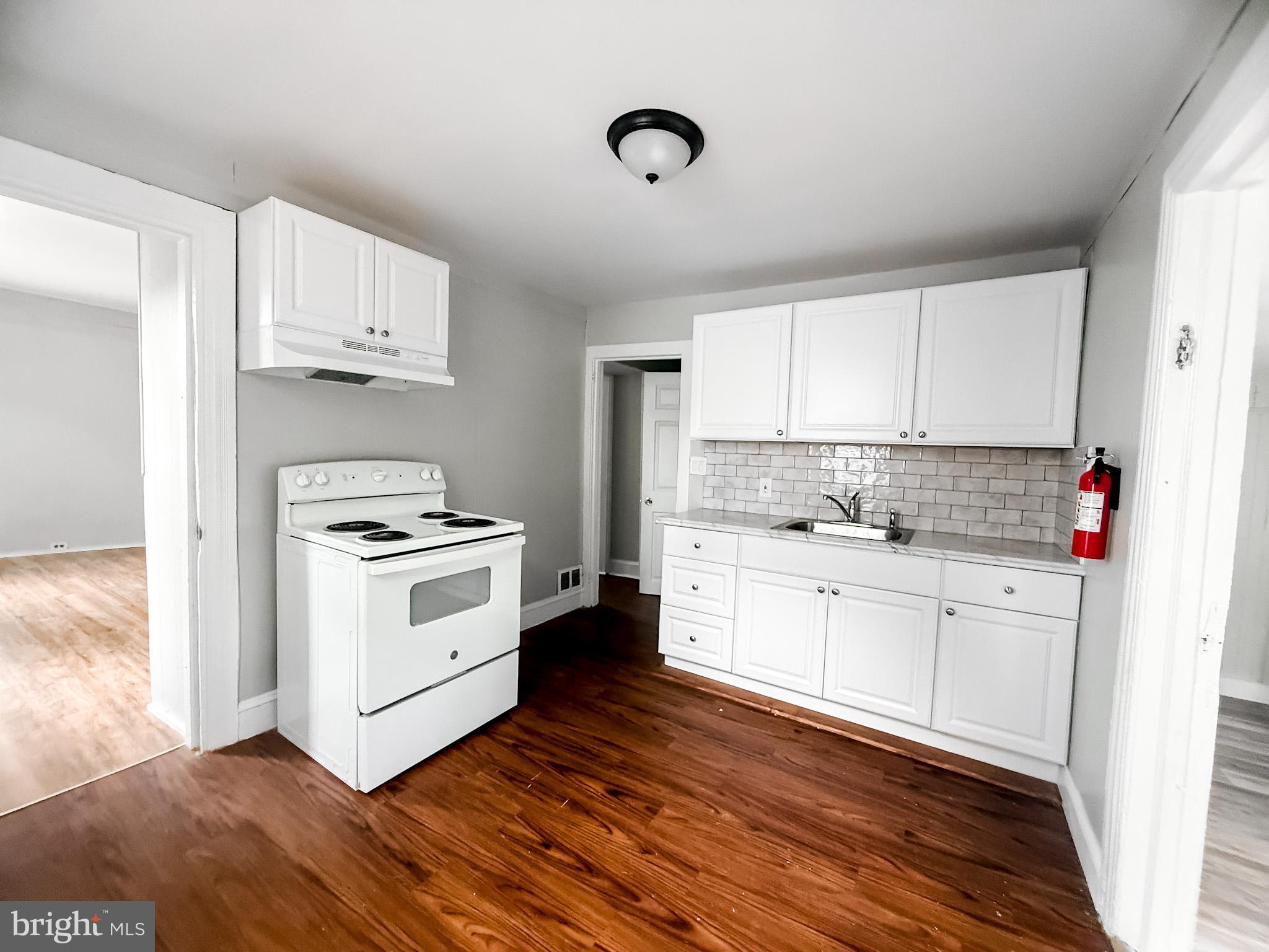 24 State Street, Unit A Penns Grove, NJ 08069 - Photo 8 of 18 a kitchen with granite countertop white cabinets and white appliances