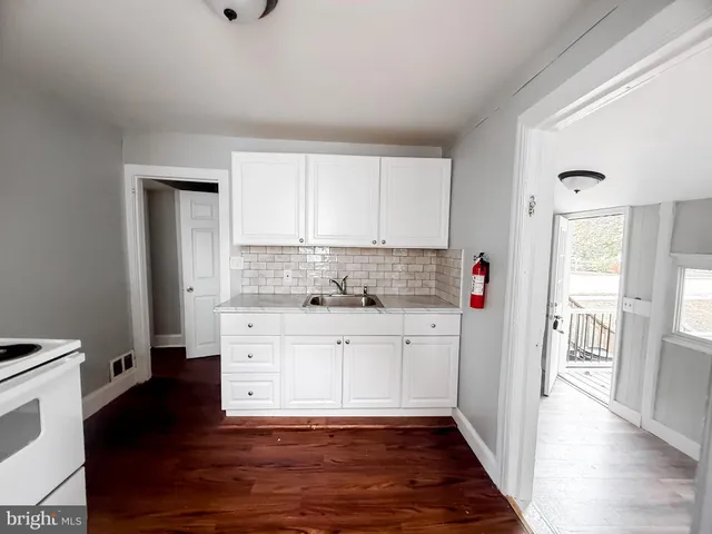 a kitchen with granite countertop white cabinets and white appliances