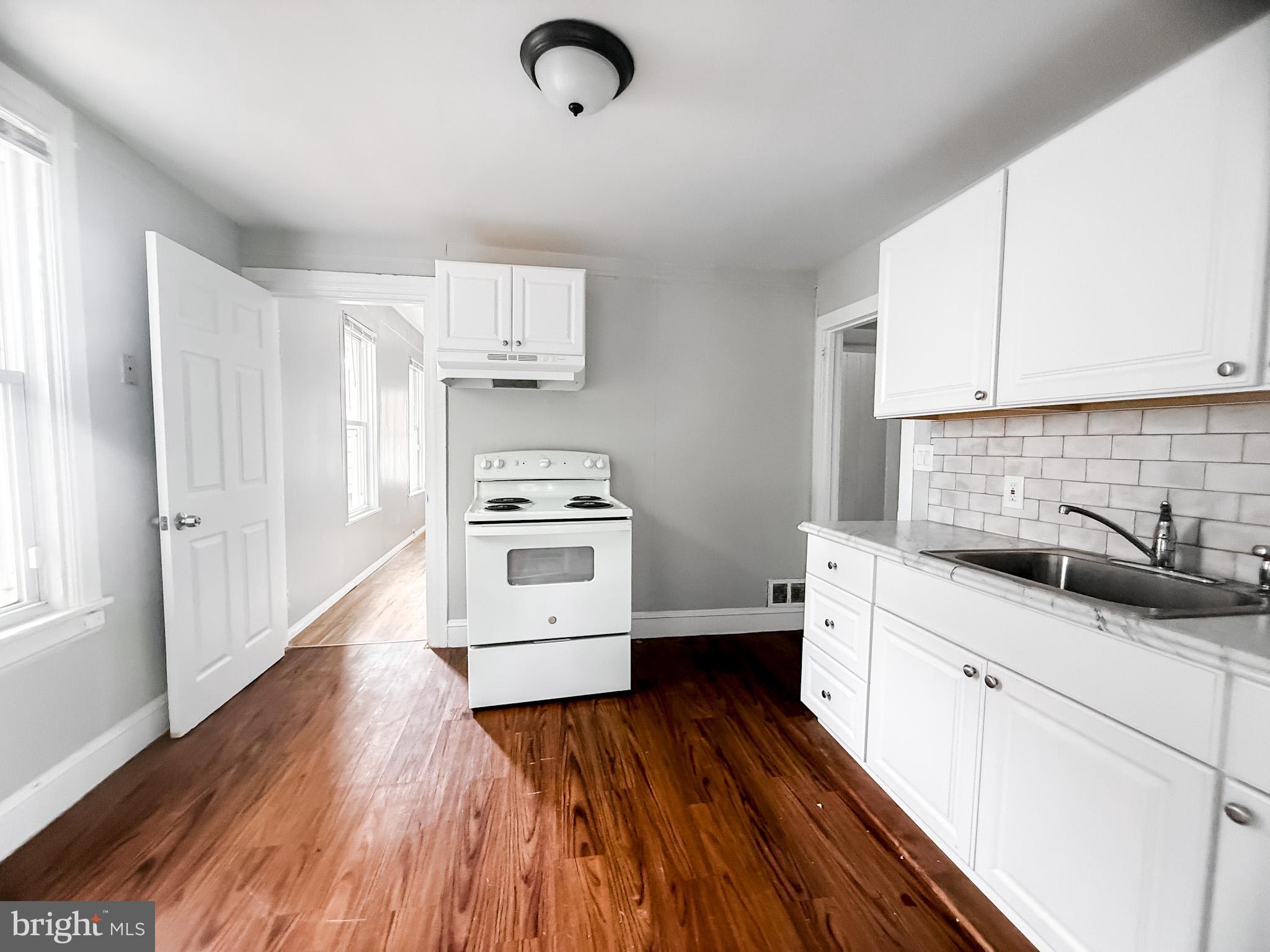 24 State Street, Unit A Penns Grove, NJ 08069 - Photo 10 of 18 a kitchen with granite countertop a sink cabinets and wooden floor