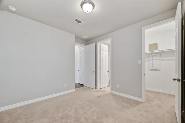 an empty room with closet and windows