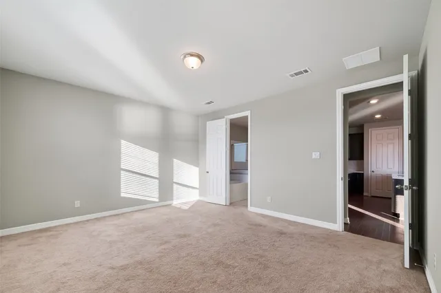 an empty room with windows and cabinet