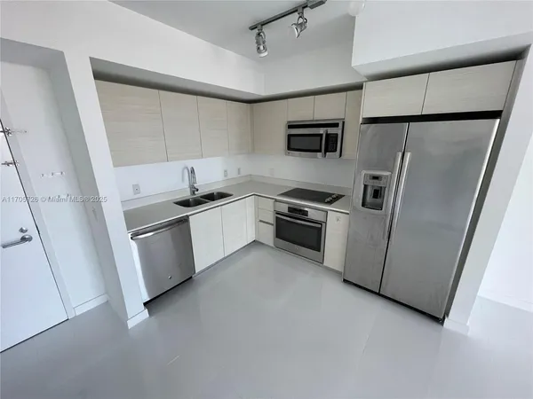 a kitchen with white cabinets sink and stainless steel appliances
