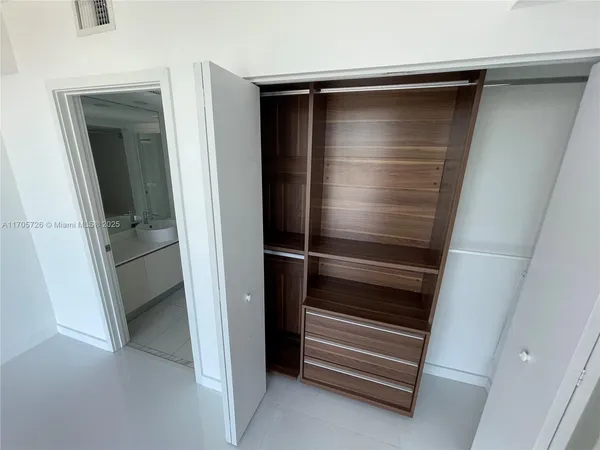 a view of a storage & utility room with a refrigerator