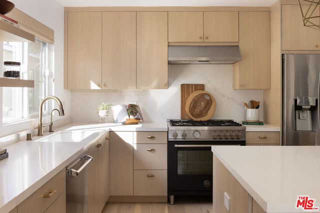 a kitchen with granite countertop a sink stove and cabinets
