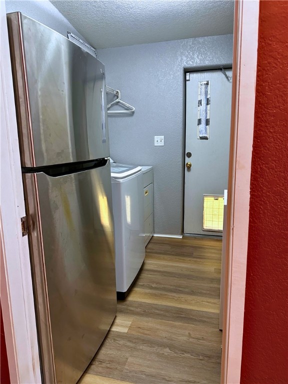 3746 Bouse Road Golden Valley, AZ 86413 - Photo 12 of 53 Washroom with a textured wall, wood finished floors, a textured ceiling, and washing machine and dryer