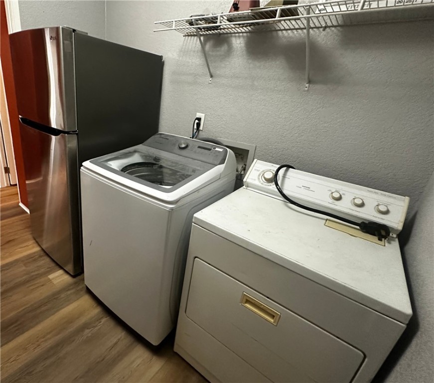 3746 Bouse Road Golden Valley, AZ 86413 - Photo 14 of 53 Laundry room featuring a textured wall, light wood-style floors, and separate washer and dryer