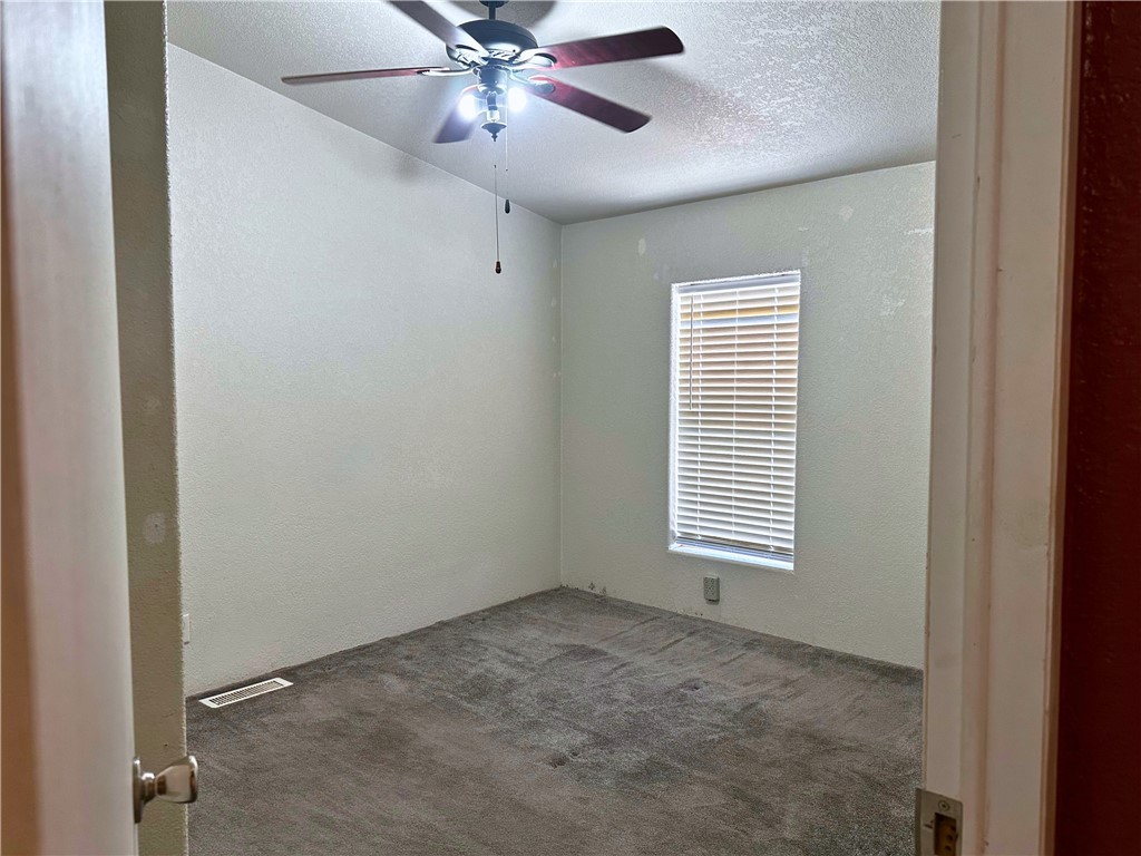 3746 Bouse Road Golden Valley, AZ 86413 - Photo 16 of 53 Empty room with a textured wall, carpet floors, a textured ceiling, and ceiling fan