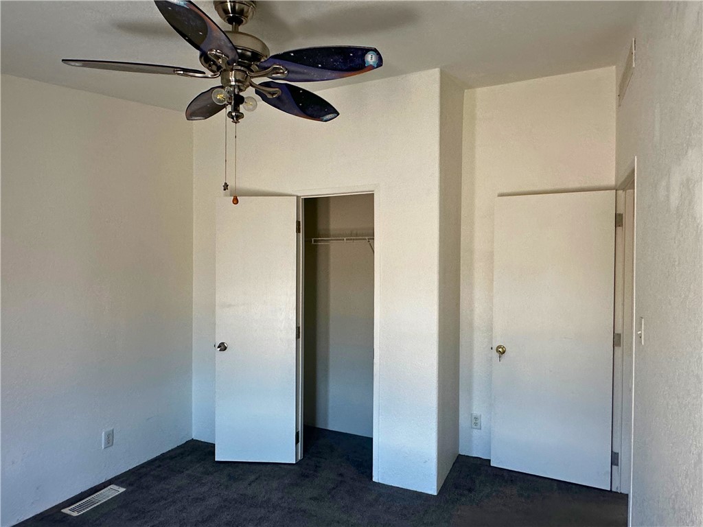 3746 Bouse Road Golden Valley, AZ 86413 - Photo 20 of 53 Unfurnished bedroom with dark colored carpet, a closet, and ceiling fan