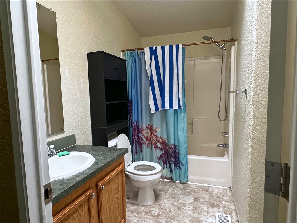 3746 Bouse Road Golden Valley, AZ 86413 - Photo 32 of 53 Bathroom featuring a textured wall, vanity, and shower / bath combo with shower curtain