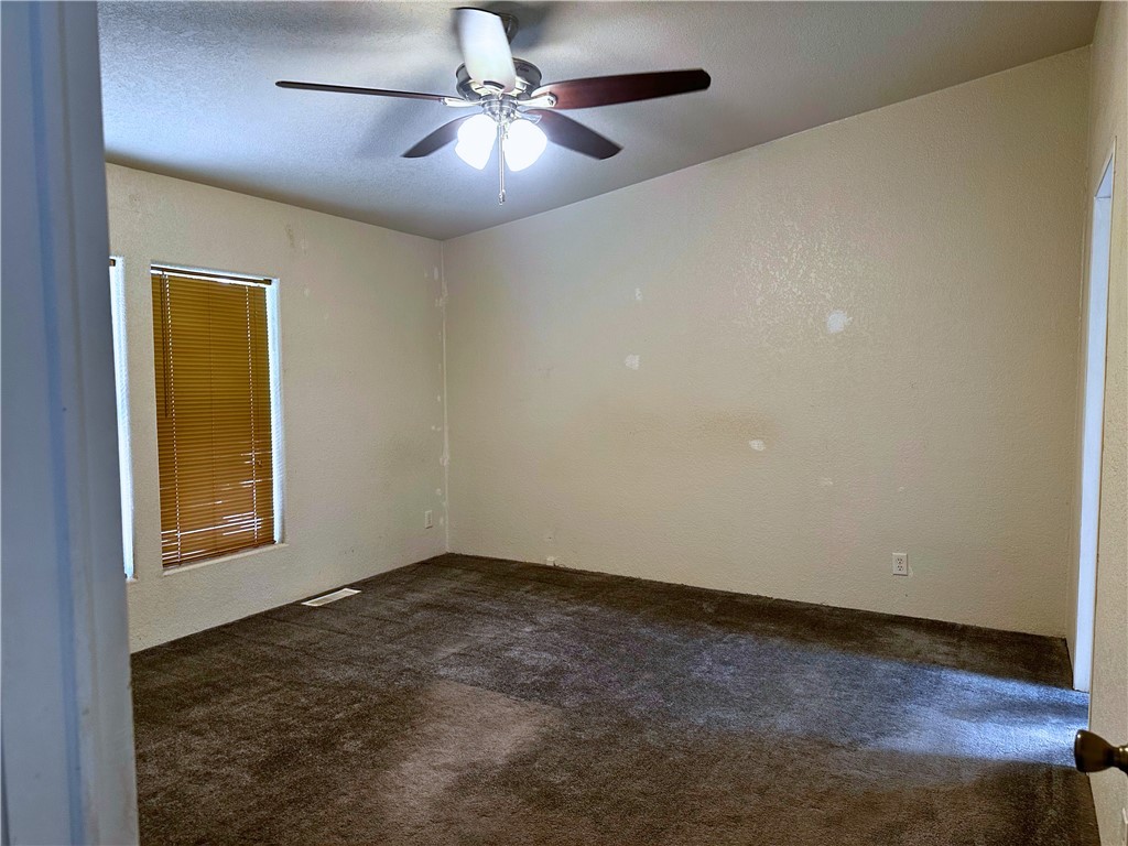 3746 Bouse Road Golden Valley, AZ 86413 - Photo 33 of 53 Carpeted empty room featuring ceiling fan, a textured wall, and a textured ceiling