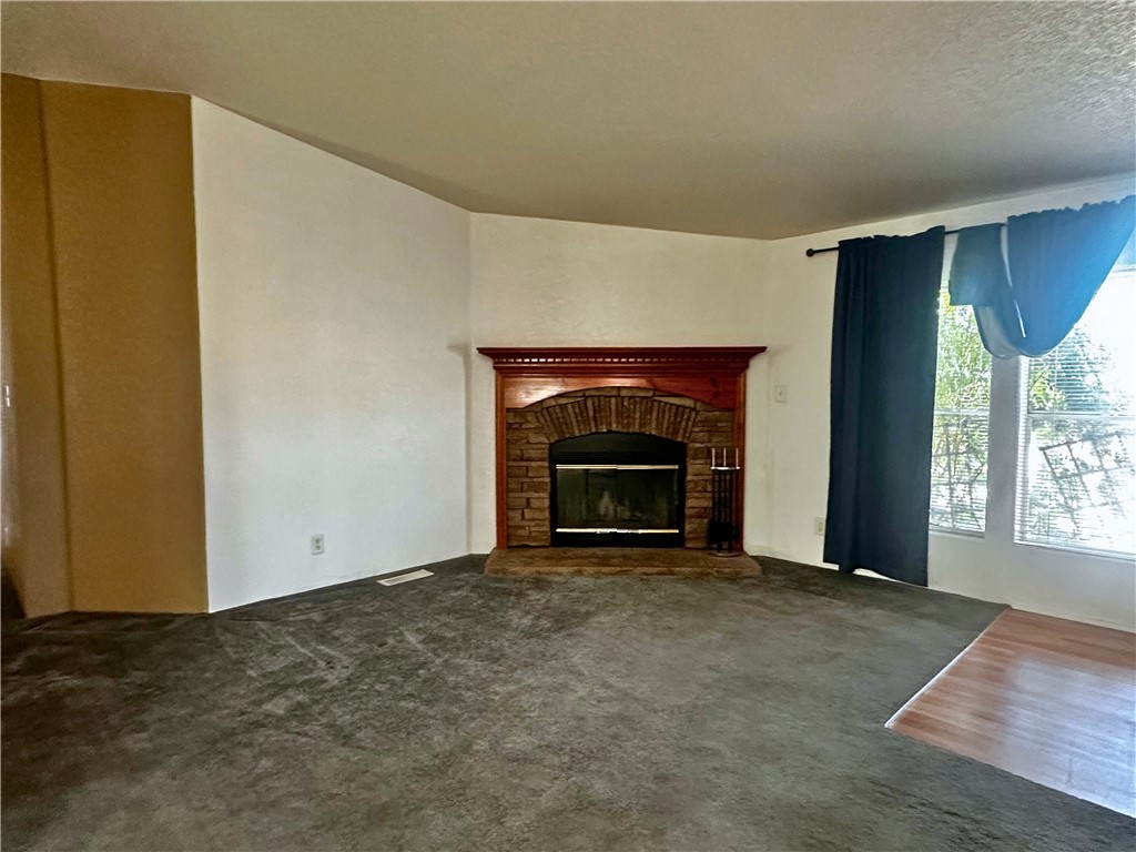 3746 Bouse Road Golden Valley, AZ 86413 - Photo 5 of 53 Unfurnished living room with a brick fireplace and carpet