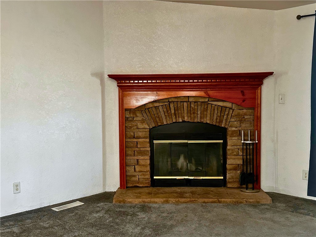 3746 Bouse Road Golden Valley, AZ 86413 - Photo 6 of 53 Detailed view of a textured wall, a fireplace, and carpet