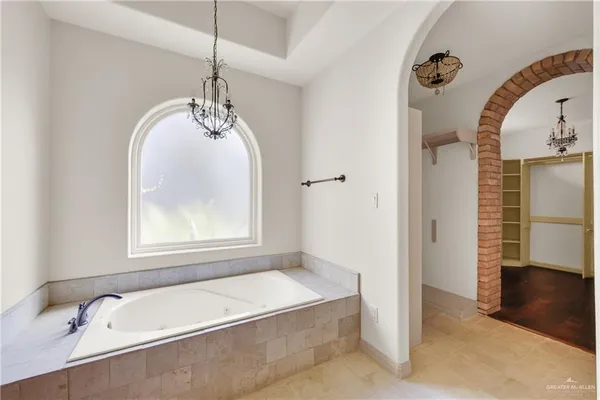 a bathroom with a tub a sink and a window