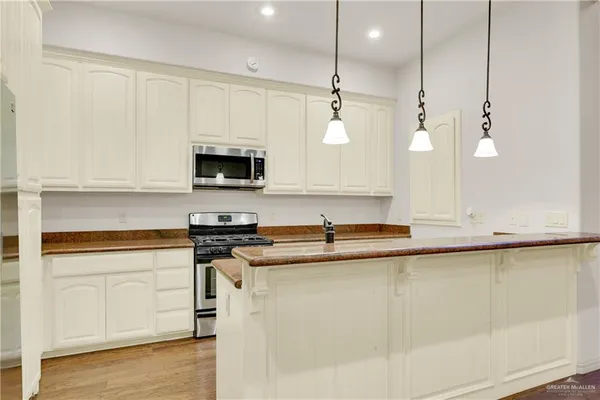 a kitchen with stainless steel appliances granite countertop a sink a stove and a microwave