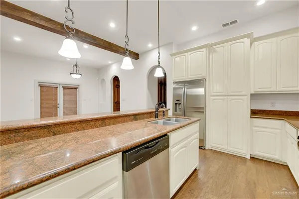 a large kitchen with a sink and refrigerator
