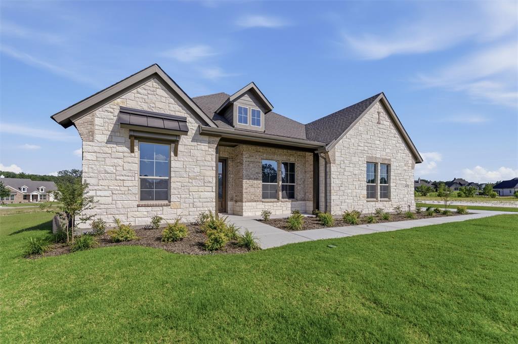 605 Tay Tay Way Springtown, TX 76082 - Photo 3 of 31 Stone facade residence featuring a dark shingle roof, a front dormer window, and mature landscaping